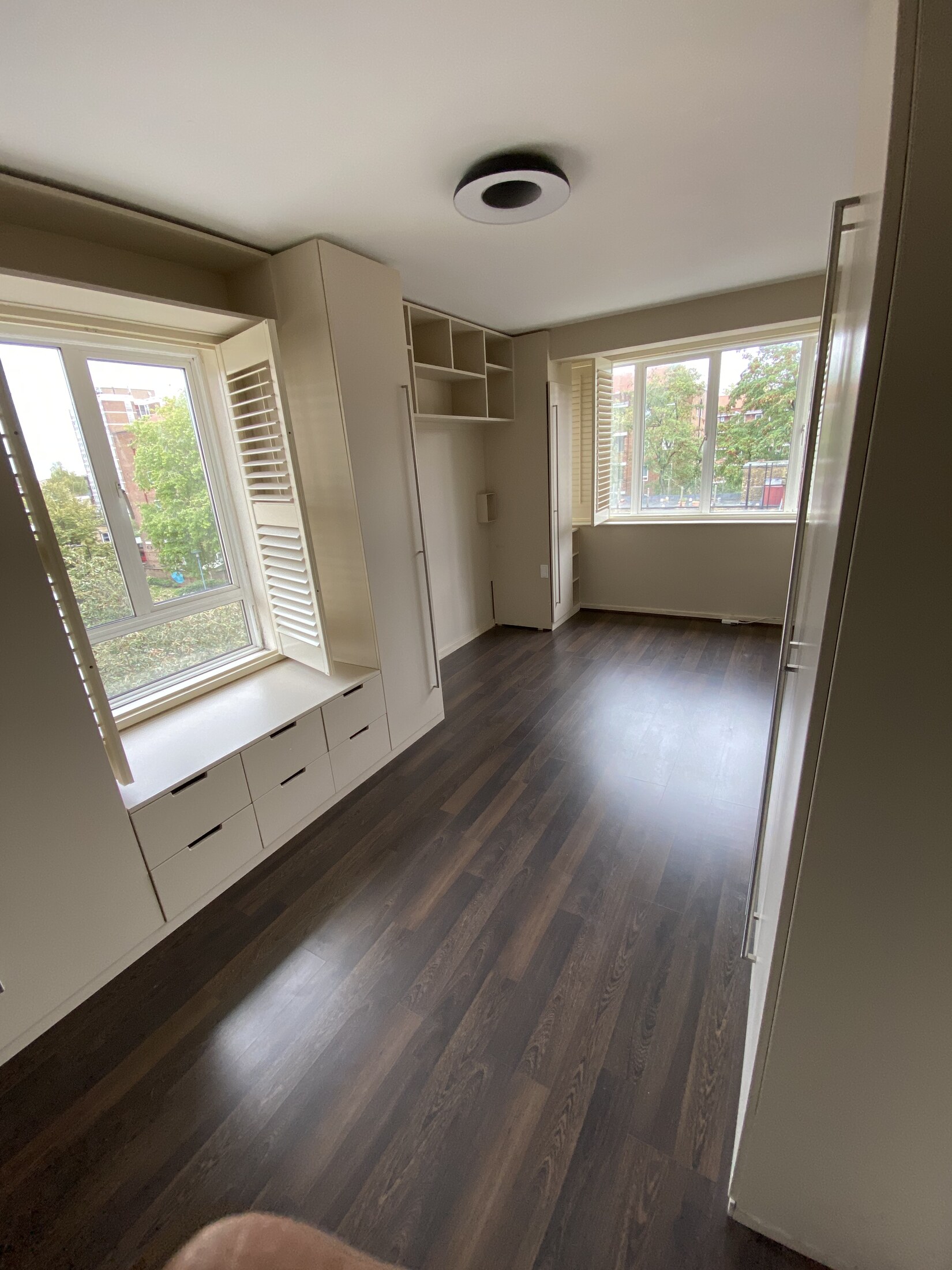 Bedroom with a bright window and fitted storage